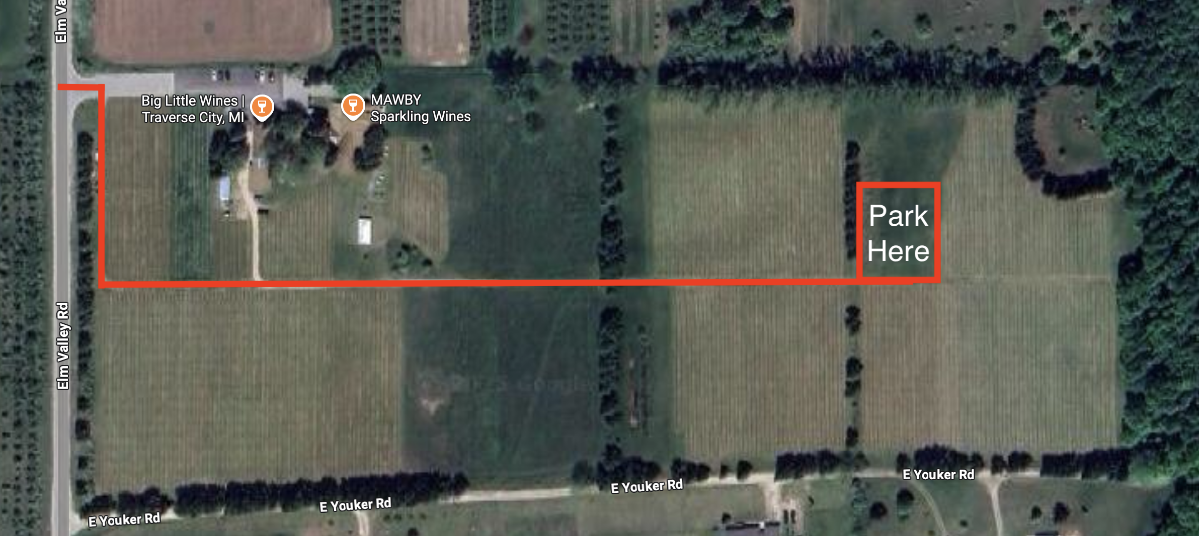 A satellite map showing vineyards near Elm Valley Road and E Youker Road in Traverse City, Michigan. A bold red line highlights a driving route from Elm Valley Road through the vineyard to a marked parking area on the east side of the property. A red box labeled &ldquo;Park Here&rdquo; indicates the designated parking spot. Nearby locations include Big Little Wines and MAWBY Sparkling Wines.